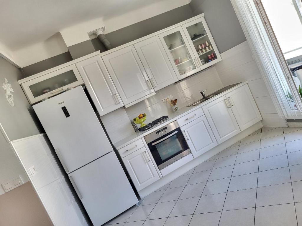 a kitchen with white cabinets and a refrigerator at ZEN in Marseille