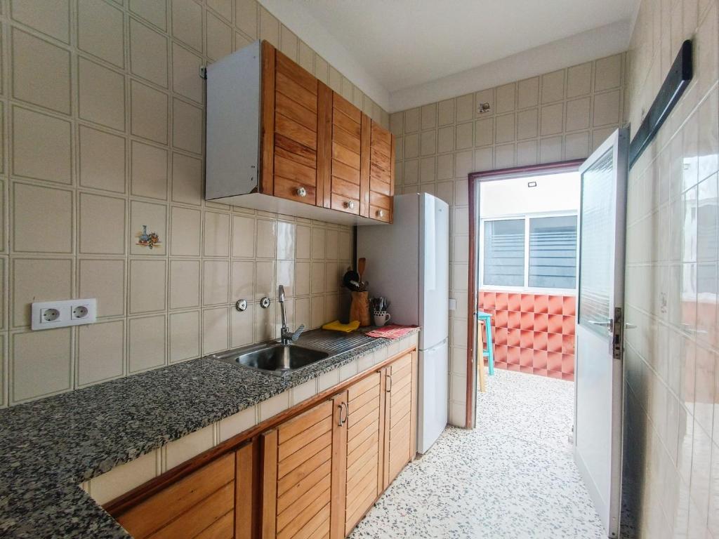 a kitchen with a sink and a refrigerator at Daydream Medano Coliving in El Médano