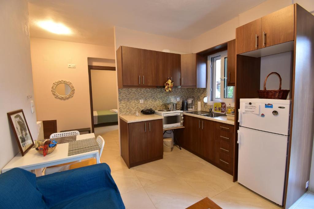 a kitchen with wooden cabinets and a white refrigerator at Magenta in Igoumenitsa