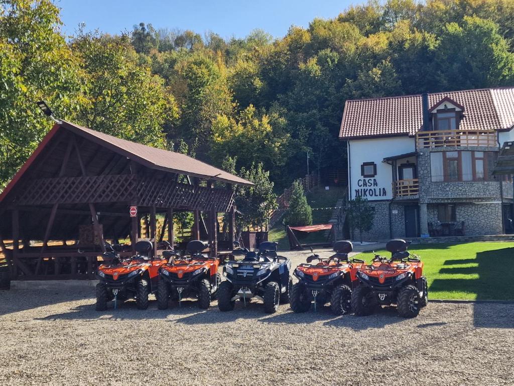 a group of four atvs parked in front of a building at Casa Nikolia in Măgura
