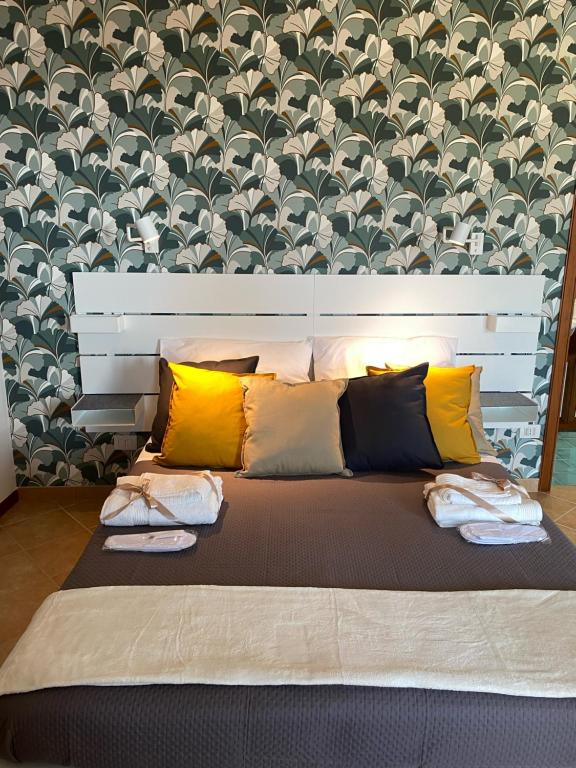 un grande letto con molti cuscini sopra di Nonna Felicia B&B a Muro Lucano