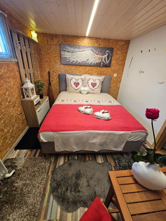 a bedroom with a large bed with red sheets and shoes on it at Chez Gigi in Apro