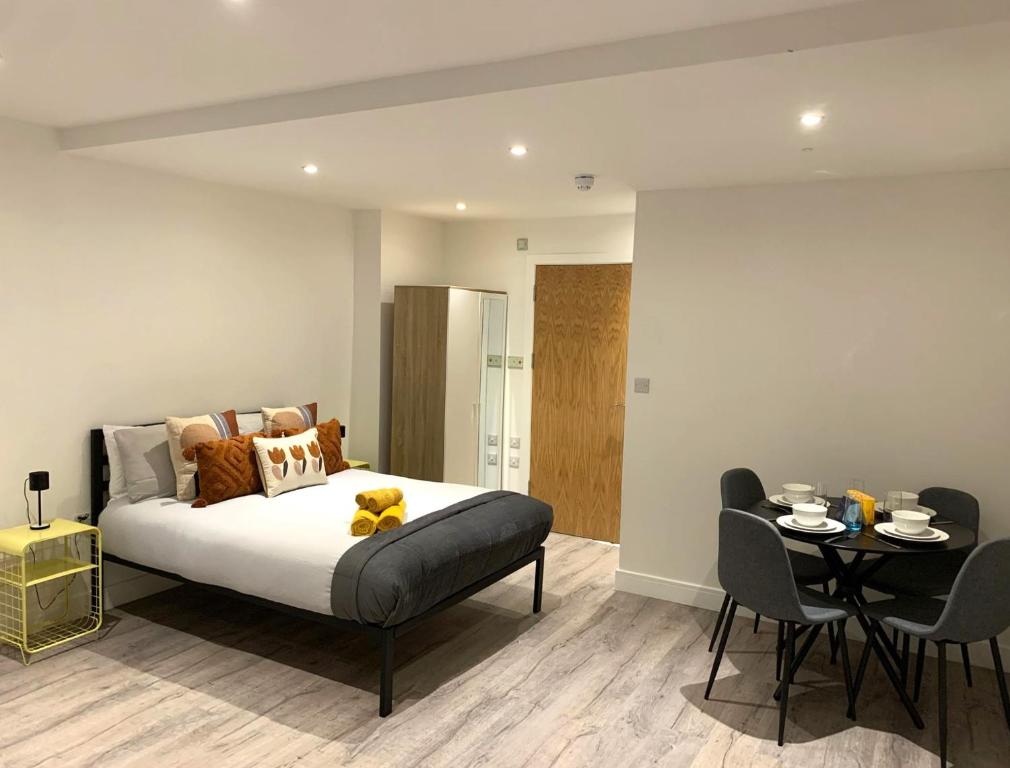- une chambre avec un lit, une table et des chaises dans l'établissement Modern Studio Flat near Highbury & Islington station, à Londres