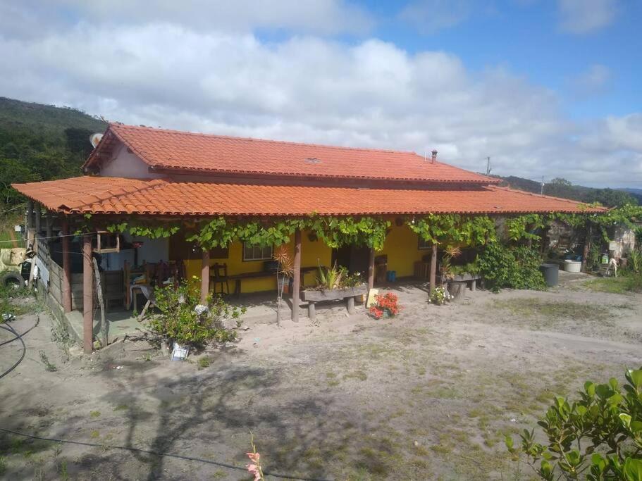 een klein huis met een oranje dak en een tuin bij Sítio Candeias - Diamantina MG in Diamantina