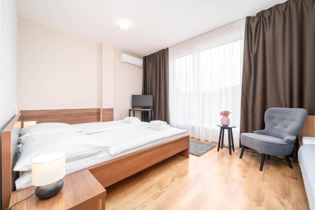ein Schlafzimmer mit einem großen Bett und einem Stuhl in der Unterkunft Hotel Aréna in Brumow