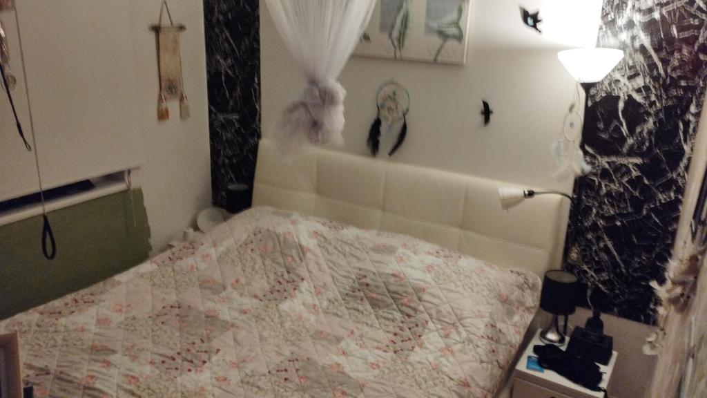 ein Schlafzimmer mit einem Bett und einer Lampe und Bildern an der Wand in der Unterkunft Day Nightand Art in Wien