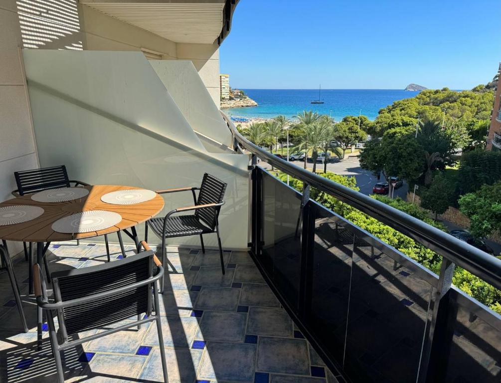 einen Balkon mit einem Tisch, Stühlen und Meerblick in der Unterkunft Seaview apartment Cala de Finestrat - Vista al mar in Villajoyosa
