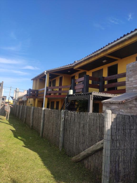 a wooden fence in front of a building at Aparts Complejo Arinos in Aguas Dulces