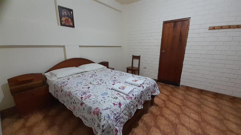 een slaapkamer met een bed met een bloemenbed bij HOSPEDAJE D`NOA En el centro de Oxapampa in Oxapampa