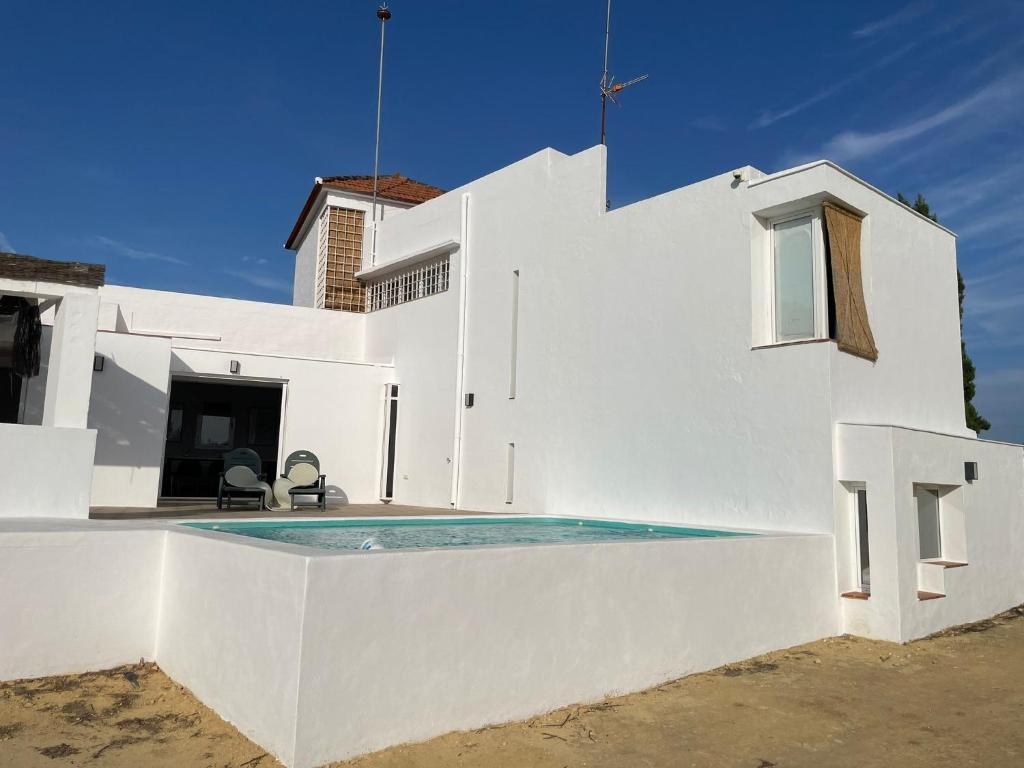 een wit huis met een zwembad ervoor bij Estupenda casa rural en Hinojos in Hinojos