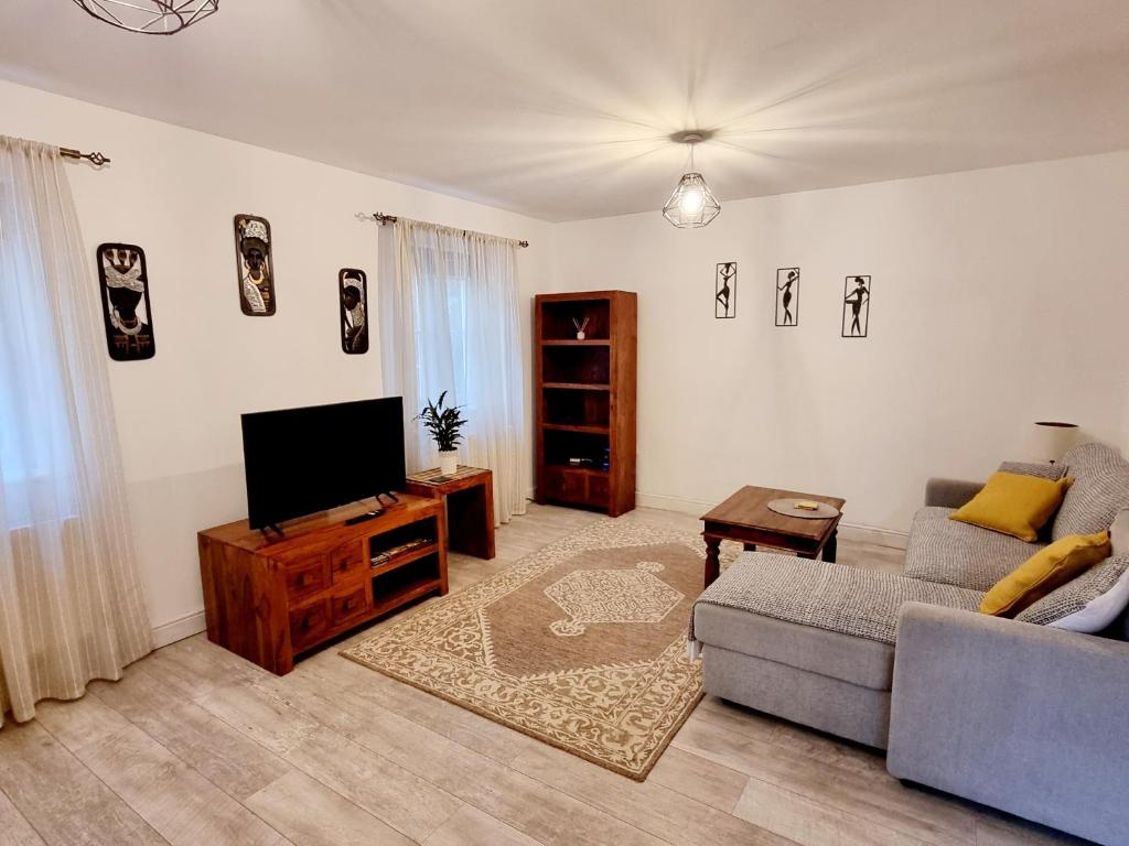 uma sala de estar com um sofá e uma televisão de ecrã plano em Spacious two bedroom apartment with one parking space em Thame