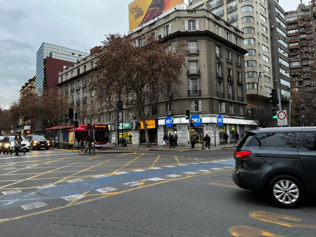 un coche está conduciendo por una concurrida calle de la ciudad en APARTAMENTO PROVIDENCIA, en Santiago