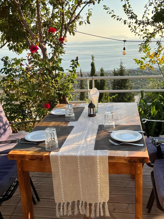 a wooden table with plates and glasses on a deck at Persephone in Himare