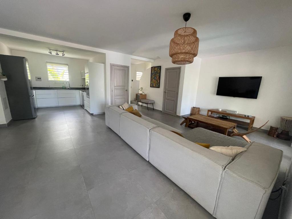 - un salon avec un canapé blanc et une télévision dans l'établissement Orient Bay Villa, à La Baie-Orientale