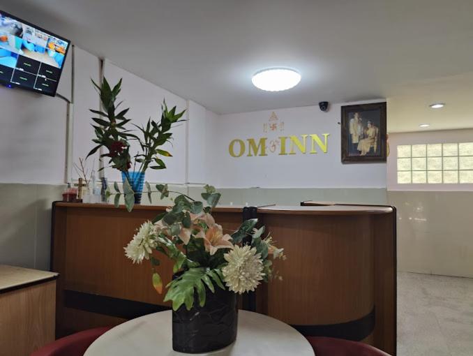 a waiting room with a table with a vase of flowers at OM INN in Bangkok