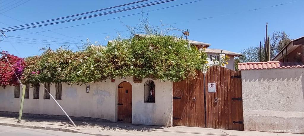 Hostal Donde Rita في فيكوينا: مبنى فيه باب خشبي وسياج