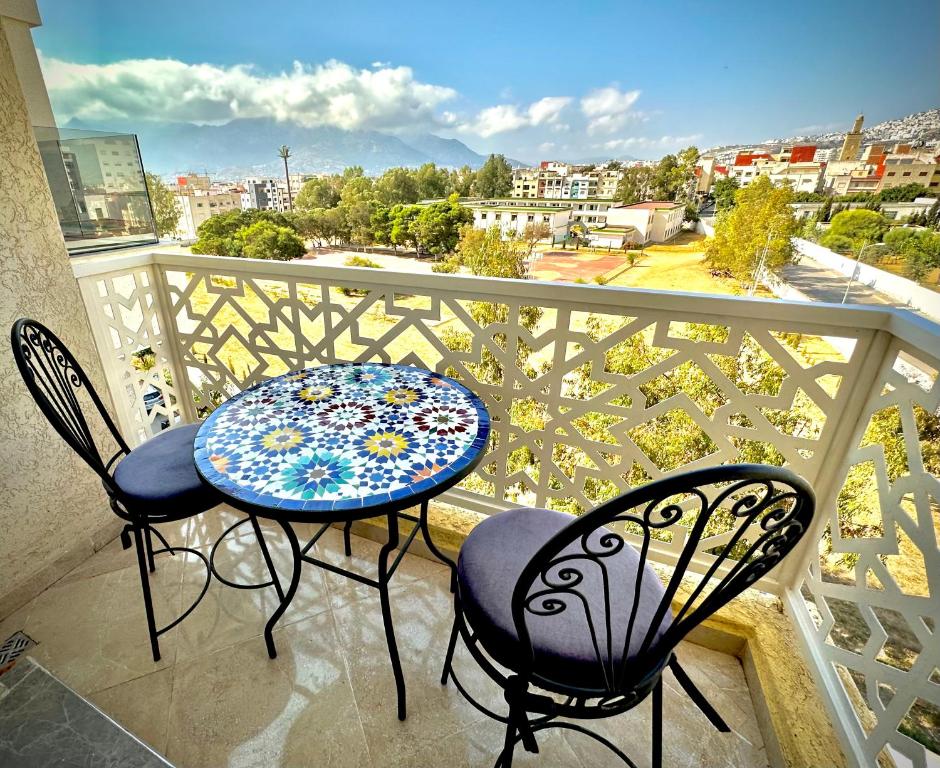 uma mesa e cadeiras numa varanda com vista em Wilaya Sunset Luxe, Private Jacuzzi & Hamam, Tetuan em Tétouan