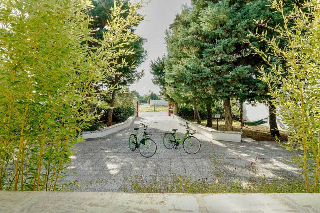 zwei Fahrräder, die auf einem Weg in einem Park geparkt sind in der Unterkunft La Terra dei Venti - Casavacanze in Porto Cesareo