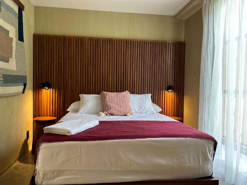 1 dormitorio con cama grande y almohada rosa en Maramara more to live en Sayulita