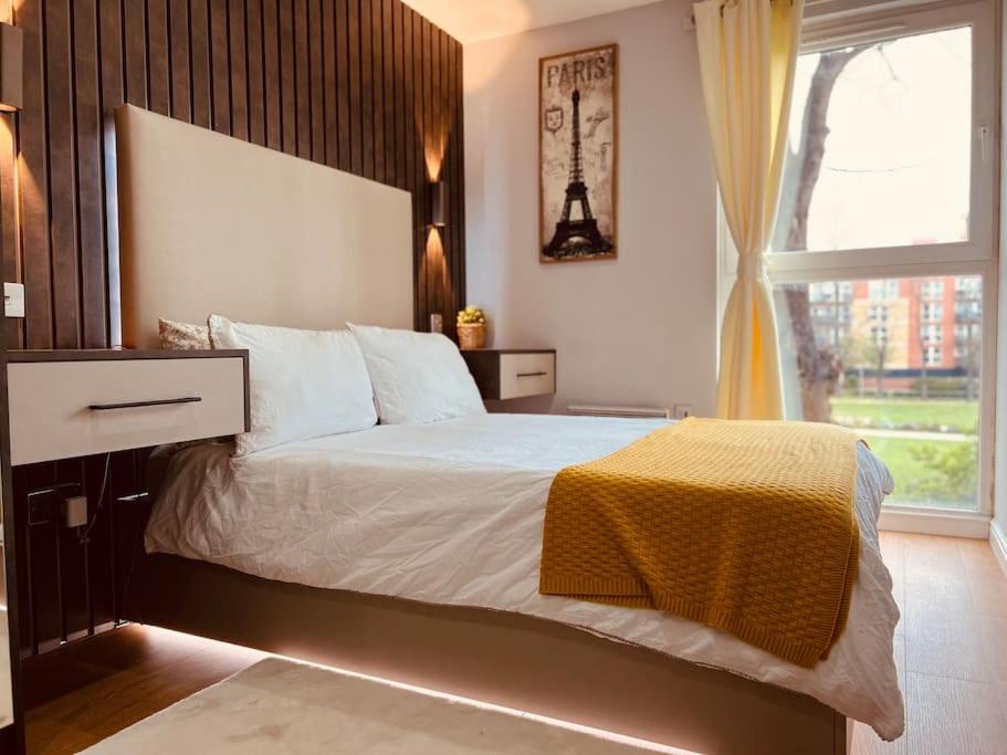 倫敦的住宿－Two Bedroom Apartment near Central Line，一间卧室设有一张大床和一个窗户。