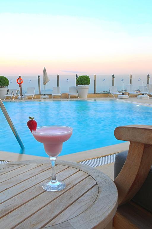 a pink drink sitting on a table next to a pool at The Marmara Taksim in Istanbul