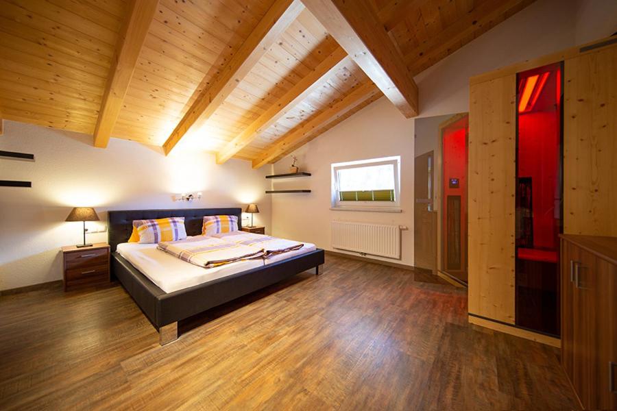 una grande camera da letto con letto e pavimenti in legno di Alpensweet by Northsouth Apartments a Sölden