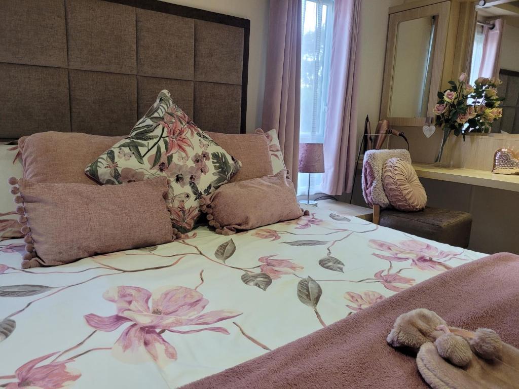 un dormitorio con una cama con un estampado de flores. en Beautiful 2 bedroom caravan, holiday park Tenby en Pembrokeshire