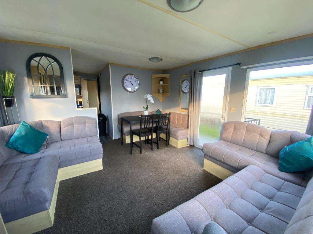 a living room with two couches and a dining room at Seaview 190 - Ingoldmells - Close to beach and Fantasy Island in Ingoldmells
