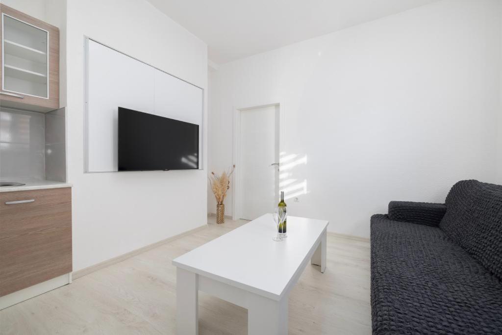 un soggiorno bianco con tavolo bianco e divano di Apartman BARIŠIĆ 1 a Kupres
