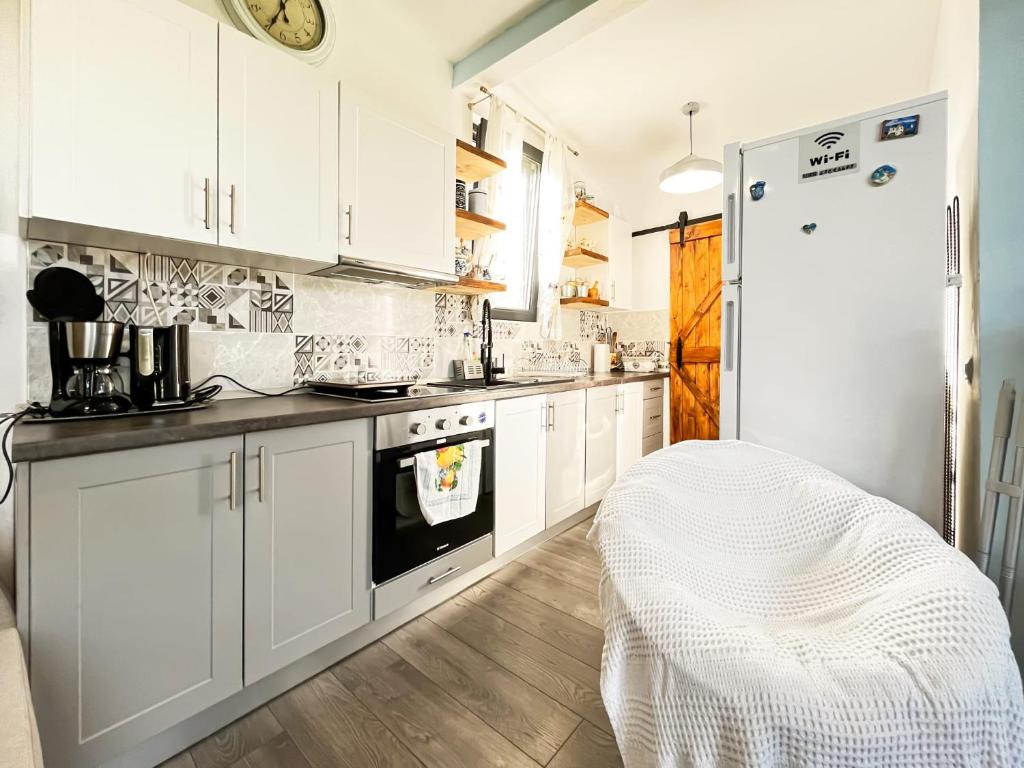 的住宿－Casuta de sub stanca Apuseni，厨房配有白色橱柜和冰箱。