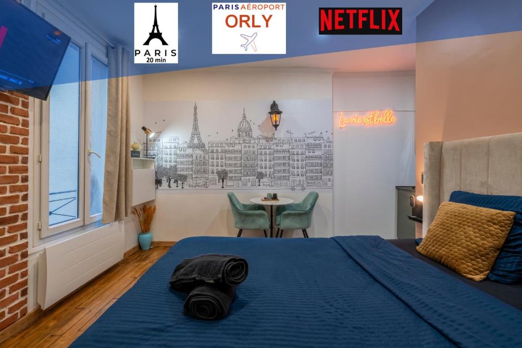 a bedroom with a bed with a blue blanket and a table at Parisian Cocoon - PARIS ORLY in Choisy-le-Roi