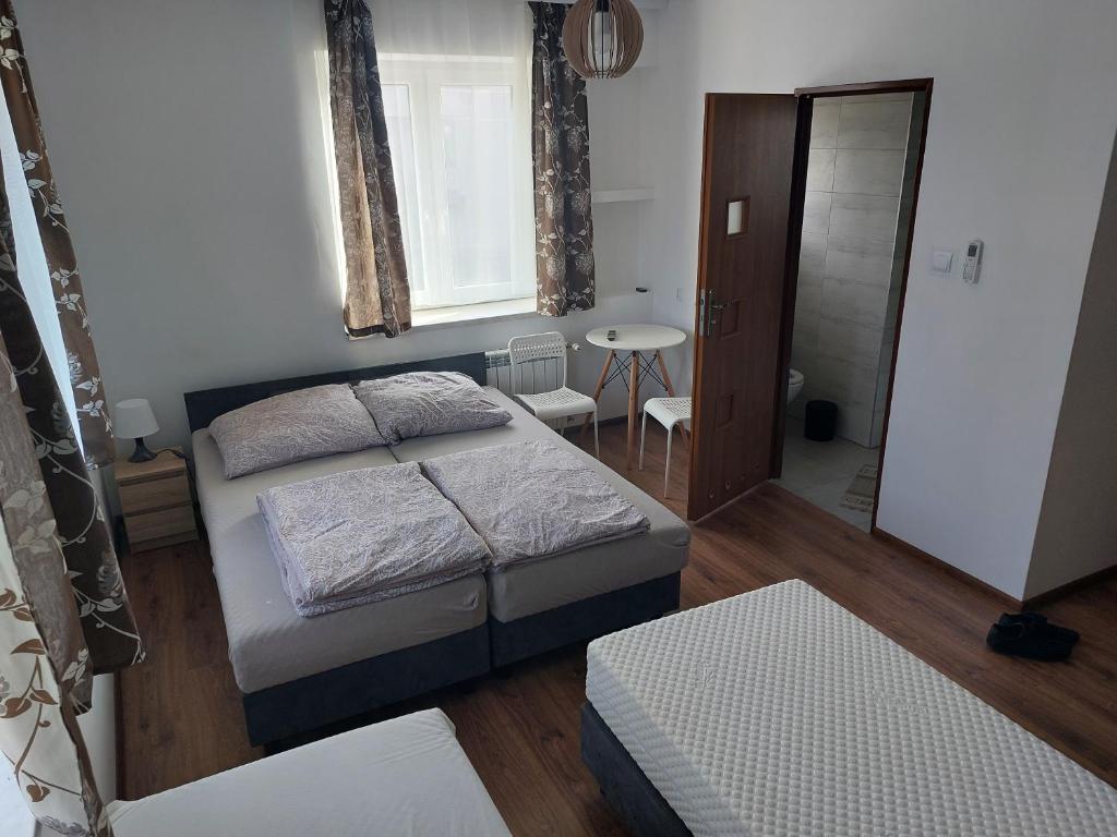 a small bedroom with two beds and a bathroom at Skotnicki Zakątek u Magdy i Tomka in Samborzec