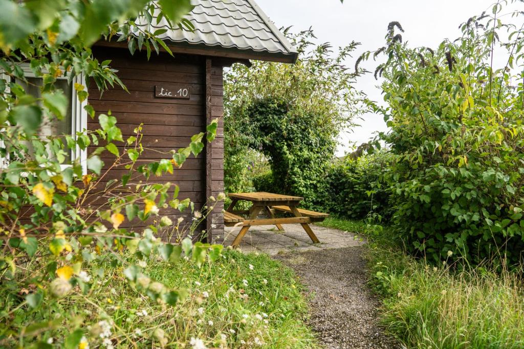 a wooden picnic table next to a wooden shed at Gite de 4 mitoyen 2 plus 2 Fécamp Etretat in Colleville