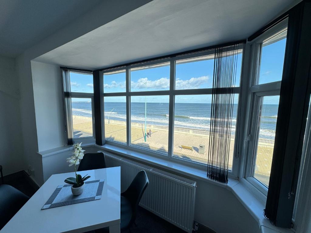 a dining room with a table and a view of the beach at Seaviews Apartment, Whitley Bay Sea Front in Whitley Bay