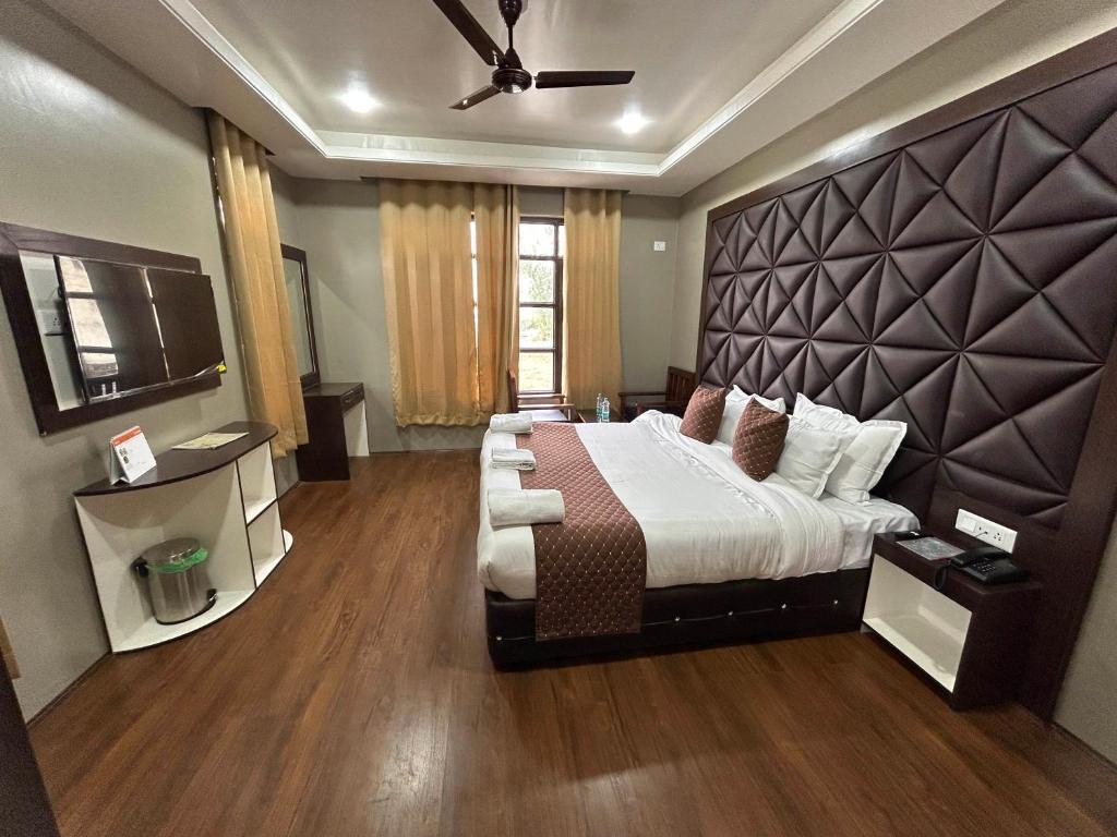 1 dormitorio con 1 cama grande y cabecero grande en Fair Mount, en Srinagar