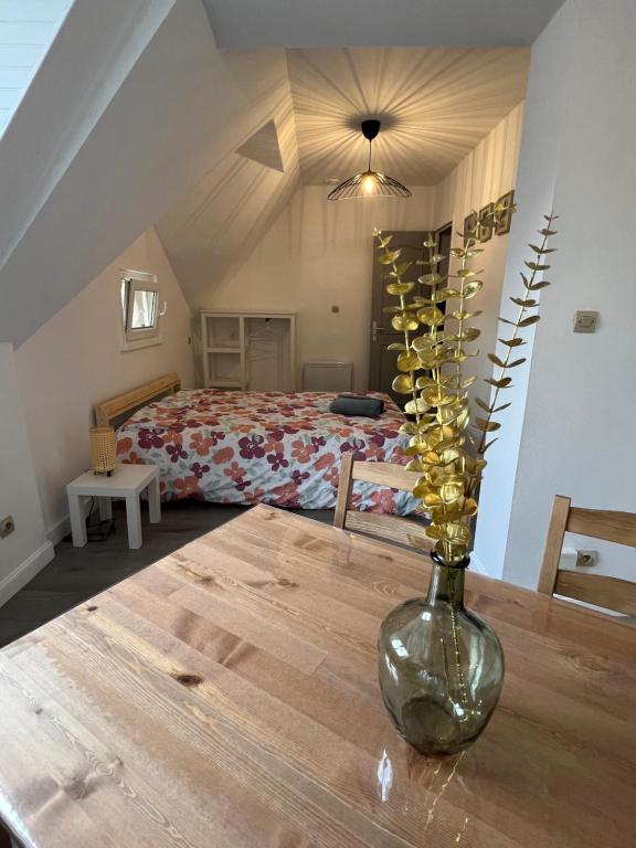 un vase sur une table en bois dans une chambre dans l'établissement Studio centre ville le saint'oh, à Saint-Omer