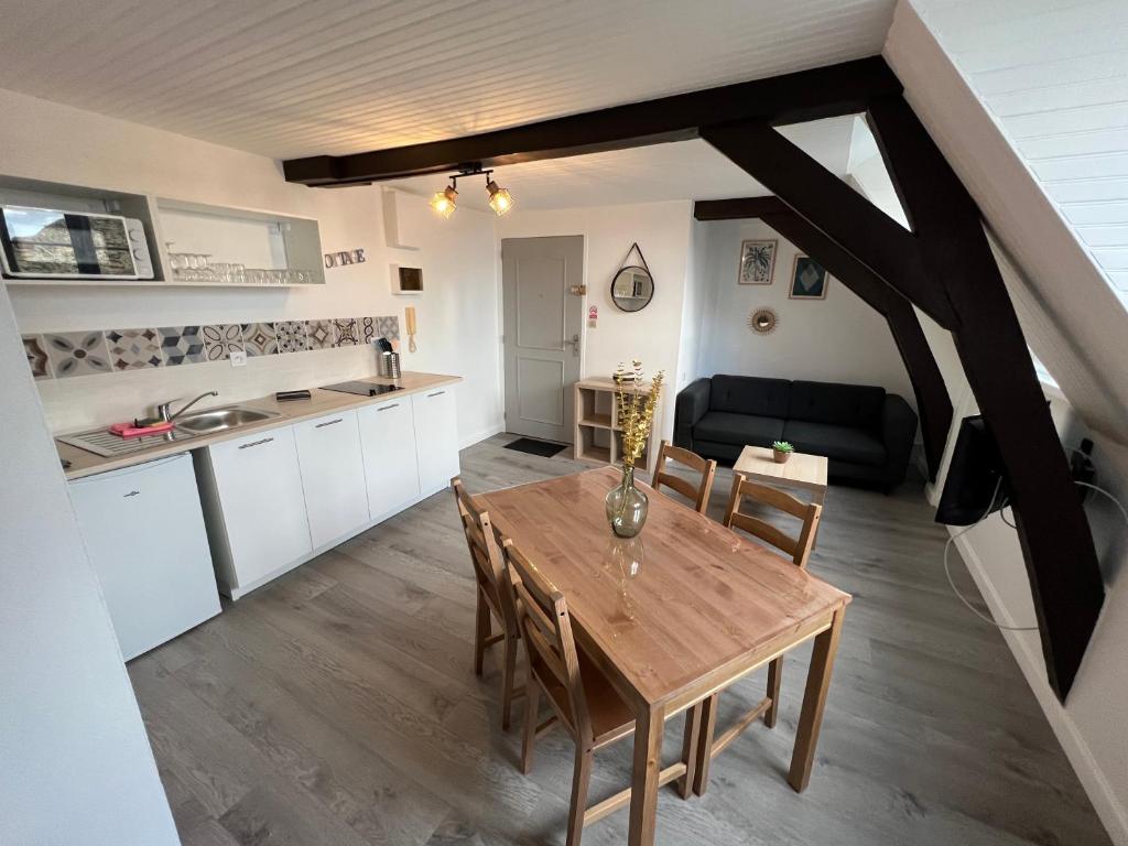 a kitchen and dining room with a wooden table and chairs at Studio centre ville le saint&#39;oh in Saint-Omer