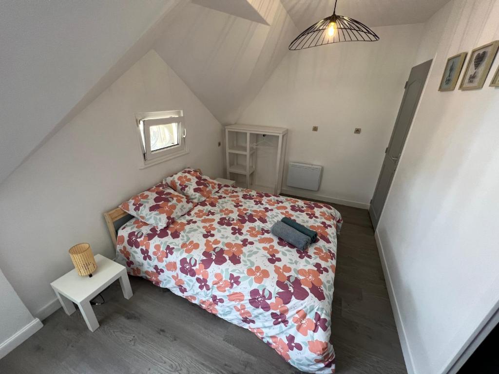 a bedroom with a bed with a floral bedspread at Studio centre ville le saint&#39;oh in Saint-Omer