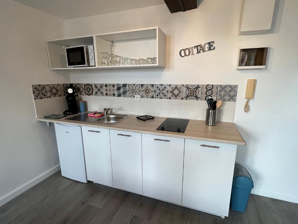 a kitchen with white cabinets and a counter top at Studio centre ville le saint&#39;oh in Saint-Omer