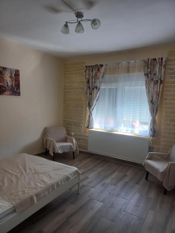LazarevoにあるВеселый домикのベッドルーム1室(ベッド1台付)、窓(カーテン付)