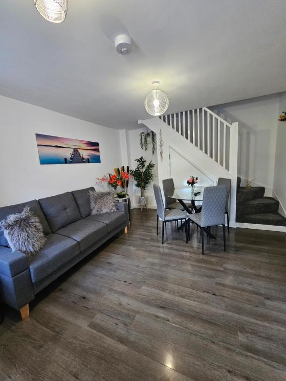 uma sala de estar com um sofá e uma mesa em Luxury one bedroom maisonette with extra connected bedroom in Stevenage centre em Stevenage