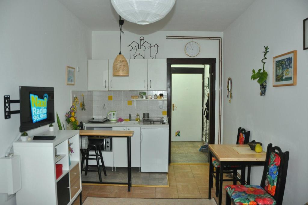 a kitchen with white cabinets and a table and a dining room at Studio5, sa parkingom, centar Obrenovca in Obrenovac