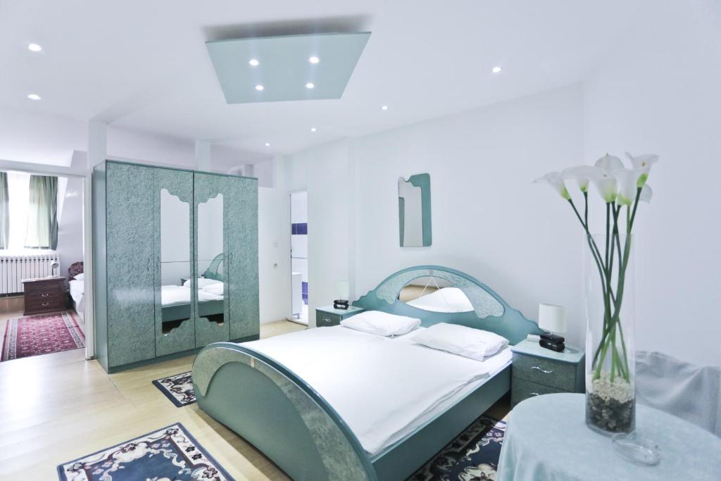 een witte slaapkamer met een bed en een tafel bij Hotel Martini Zagreb Hotel and Restaurant in Sesvete