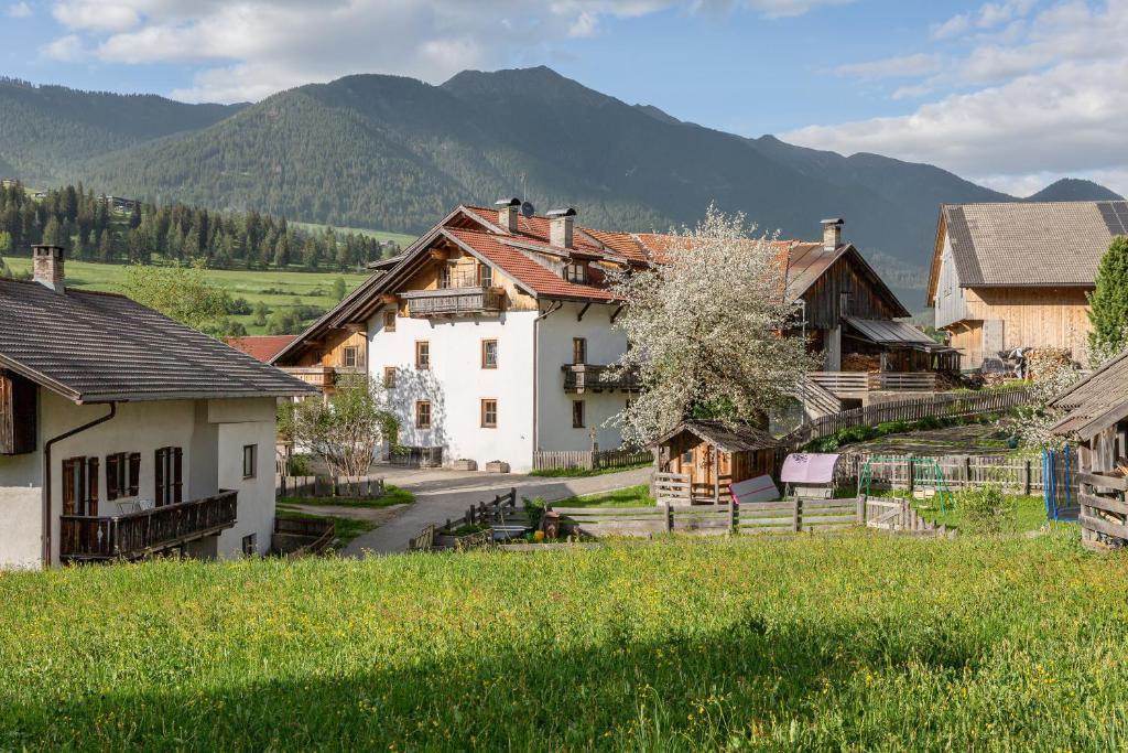 a village with houses and mountains in the background at Schusterhof - Urlaub auf dem Bauernhof in Novale