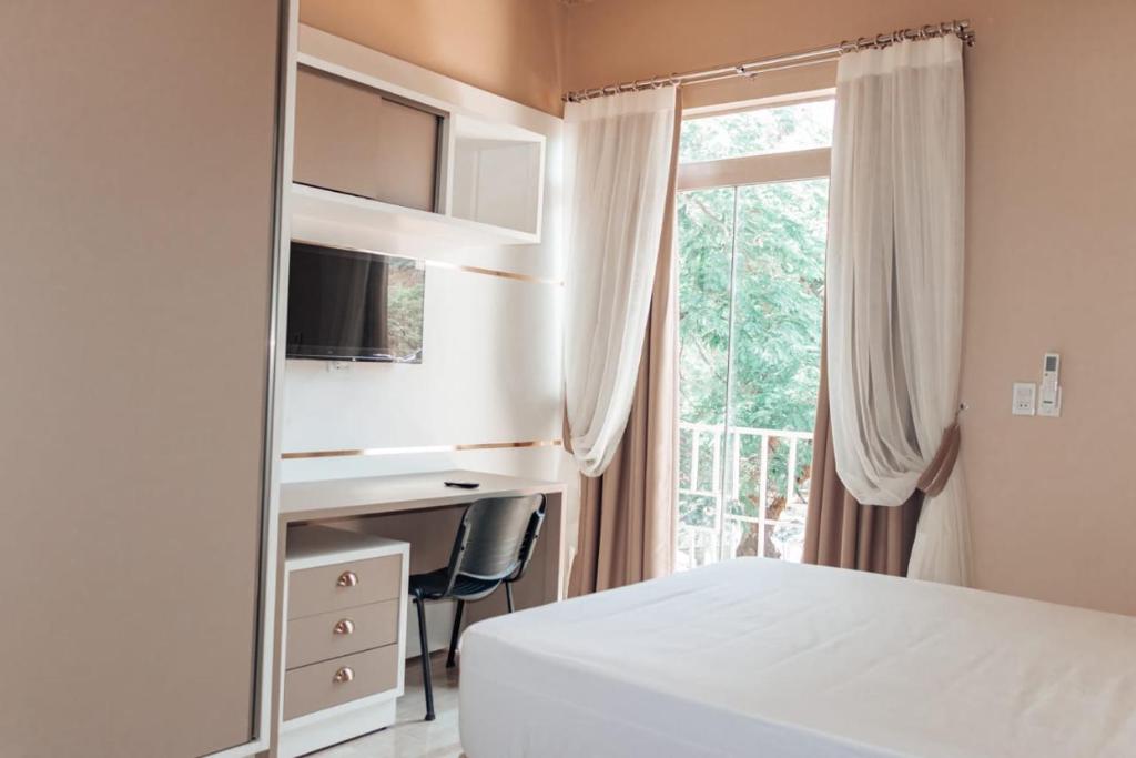 a bedroom with a mirror and a bed and a window at Urban center apartamentos in Salto del Guairá