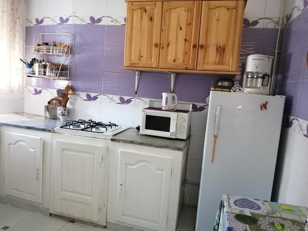 una cucina con frigorifero bianco e forno a microonde di Dar manena a Al-Qayrawan