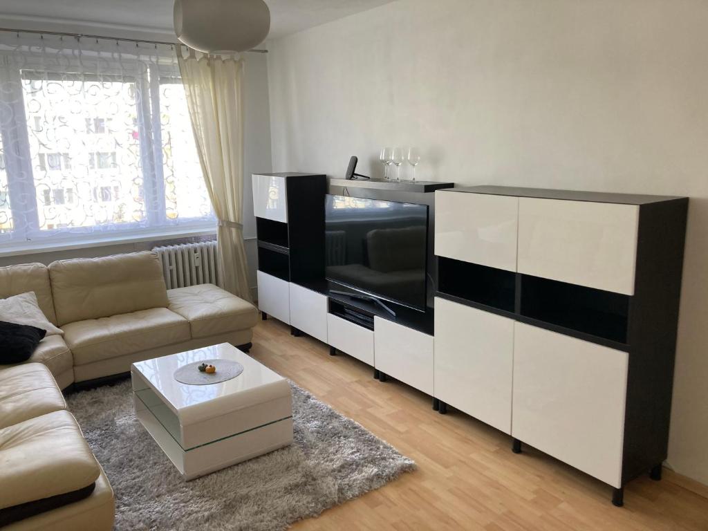 uma sala de estar com um sofá e uma televisão em 2 rooms apartment with balcony em Zvolen