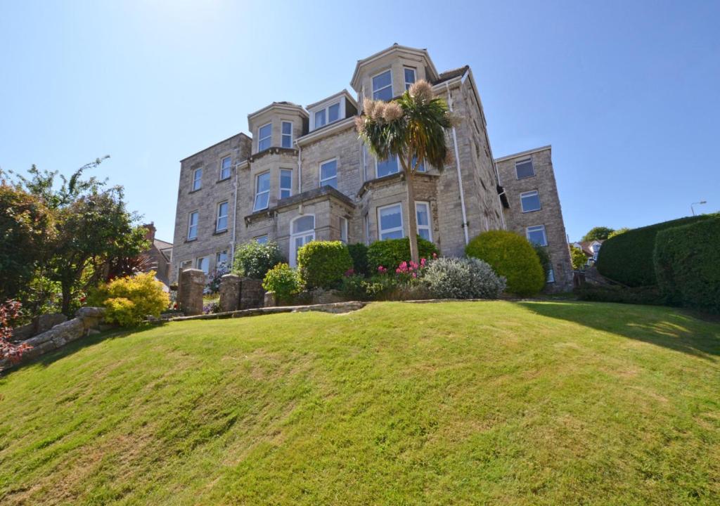 a large building on a grassy hill in front at Marys Corner in Swanage