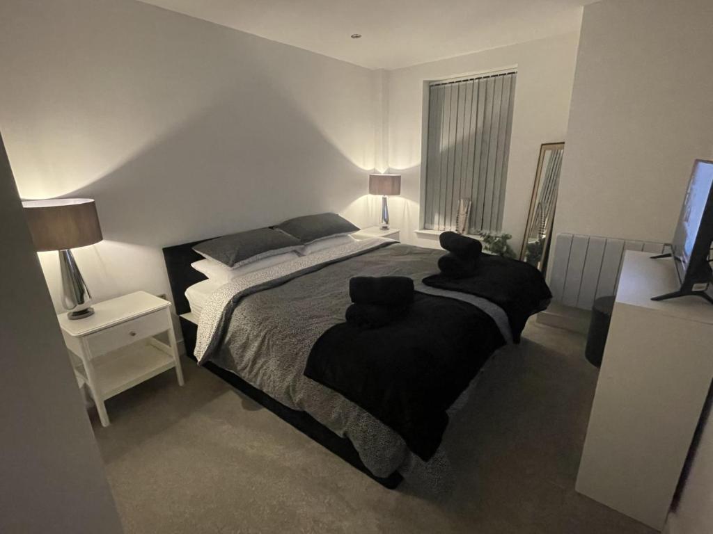 a bedroom with a large bed with two black pillows at Luxury Spring Stays Lichfield City Centre 2 Bedroom Apartment With Free Secure Parking in Lichfield