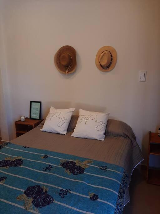 a bedroom with a bed with two hats on the wall at Temporario Necochea 2 corrientes in Corrientes